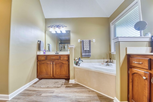 4362 Bridgestone Cir, Bartlett, TN 38135 - full bath with lofted ceiling, vanity, a garden tub, wood finished floors, and a shower