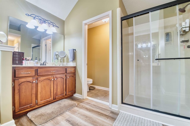 4362 Bridgestone Cir, Bartlett, TN 38135 - bathroom with a stall shower, vanity, wood finished floors, and vaulted ceiling