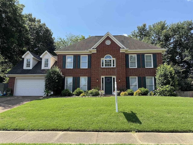 8973 E Carrollwood Ln, Memphis, TN 38016 - view of front of house featuring driveway, a front yard, brick siding, a garage, and a shingled roof