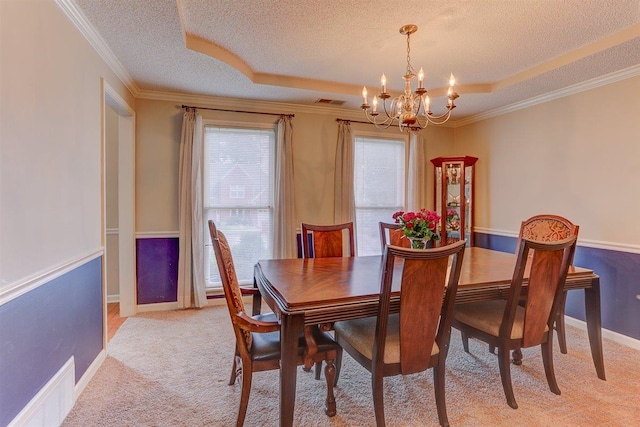 8973 E Carrollwood Ln, Memphis, TN 38016 - dining area with a chandelier, a textured ceiling, a raised ceiling, light carpet, and crown molding