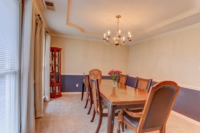 8973 E Carrollwood Ln, Memphis, TN 38016 - dining room featuring light colored carpet, a chandelier, ornamental molding, a raised ceiling, and a textured ceiling