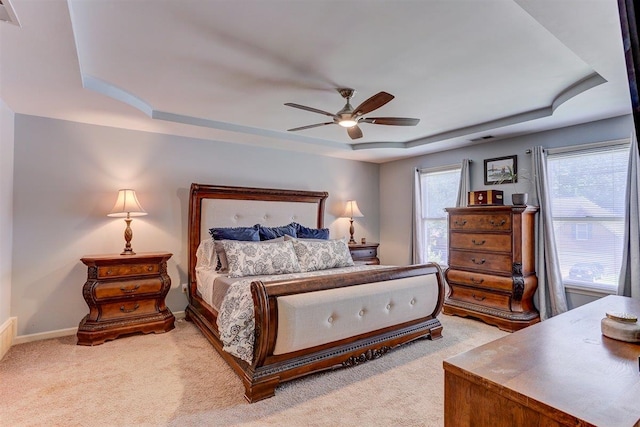 8973 E Carrollwood Ln, Memphis, TN 38016 - bedroom featuring a tray ceiling, light carpet, and ceiling fan