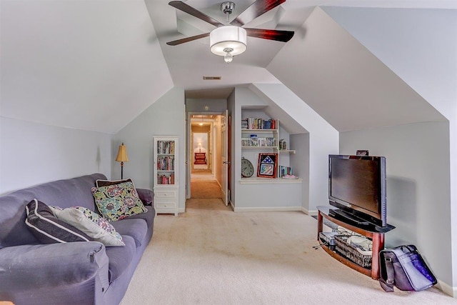 8973 E Carrollwood Ln, Memphis, TN 38016 - living area with light colored carpet, built in shelves, vaulted ceiling, and a ceiling fan