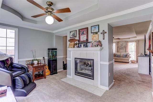 8973 E Carrollwood Ln, Memphis, TN 38016 - living room with a raised ceiling, light carpet, ceiling fan, a tile fireplace, and ornamental molding