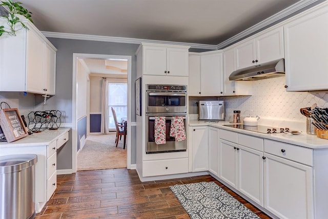 8973 E Carrollwood Ln, Memphis, TN 38016 - kitchen with stainless steel double oven, under cabinet range hood, dark wood finished floors, light countertops, and white cabinets