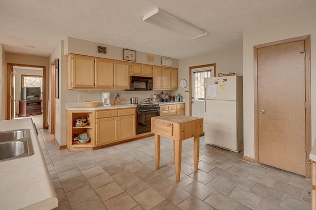 kitchen with a healthy amount of sunlight, light tile floors, and black appliances