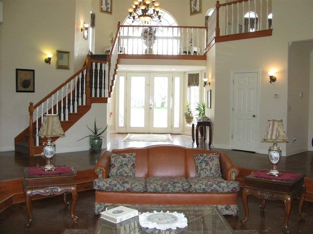 living room with a chandelier, french doors, and a towering ceiling