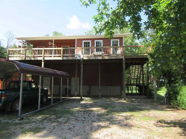 rear view of property featuring a balcony and a carport