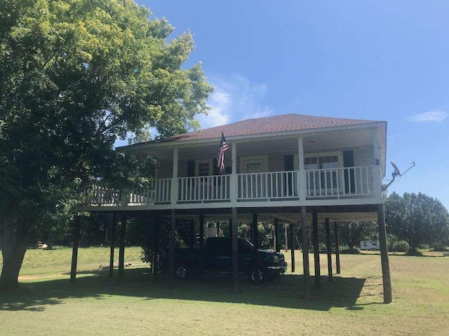 back of house with a yard, a balcony, and a carport