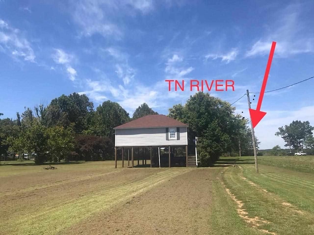 view of front of home featuring a front lawn and a rural view