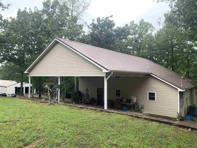 rear view of property with a patio, central AC, and a yard