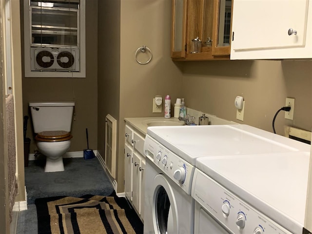 clothes washing area with dark colored carpet, washer and dryer, and sink