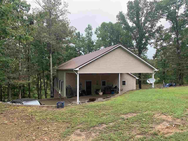 back of property featuring a patio area and a yard