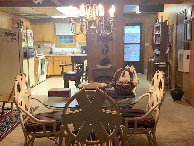 carpeted dining area with sink, wood walls, and a chandelier