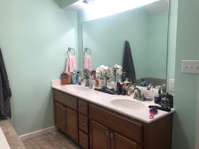 bathroom with tile floors and dual bowl vanity