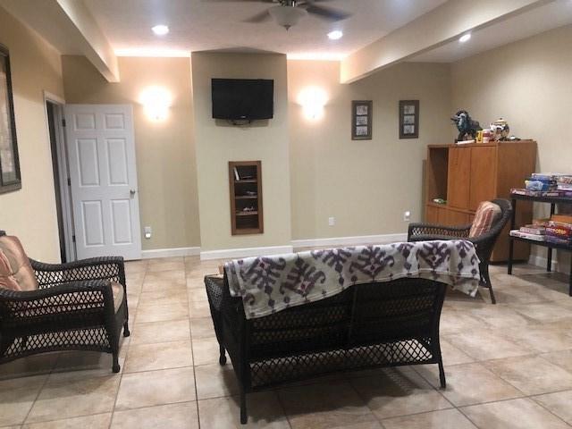 sitting room featuring light tile floors and ceiling fan