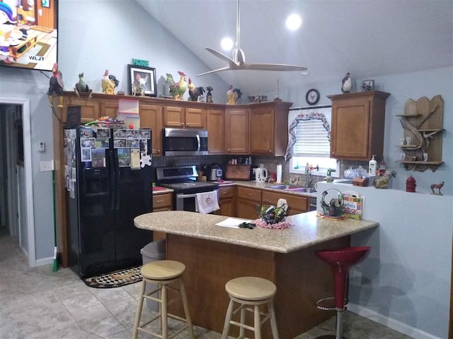 kitchen with appliances with stainless steel finishes, tasteful backsplash, lofted ceiling, a kitchen breakfast bar, and kitchen peninsula