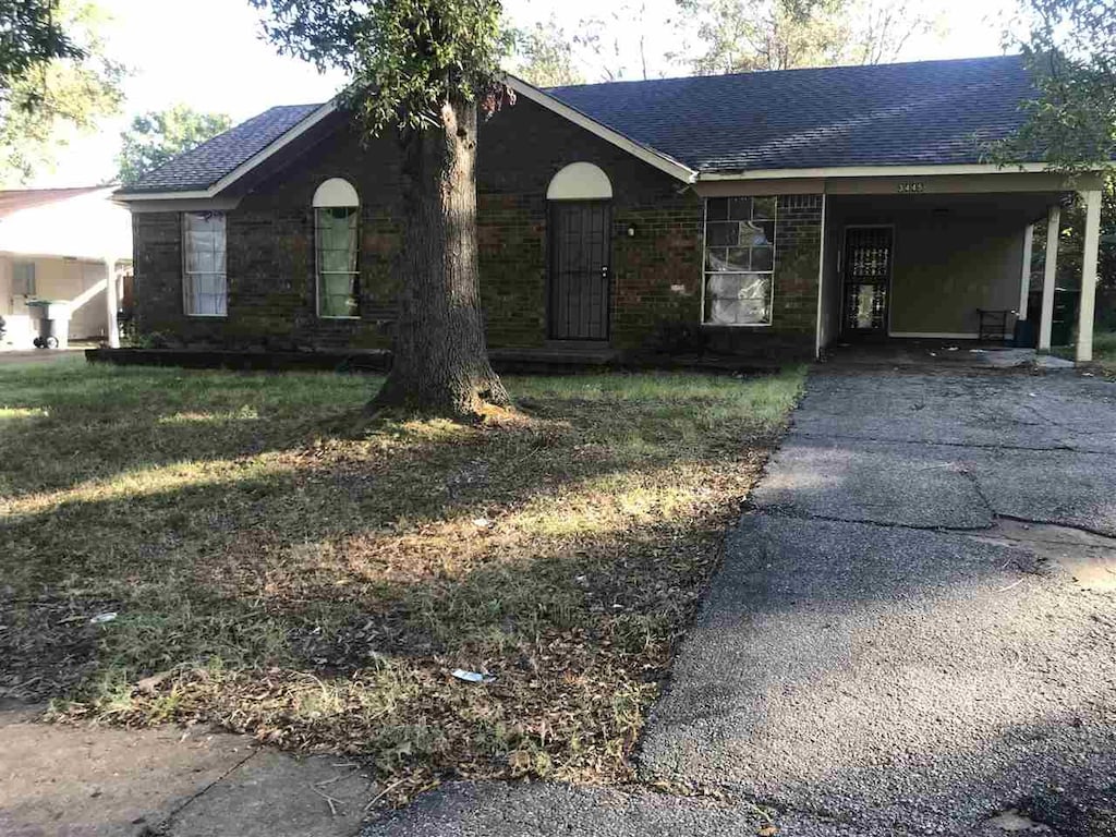 single story home with a carport and a front lawn