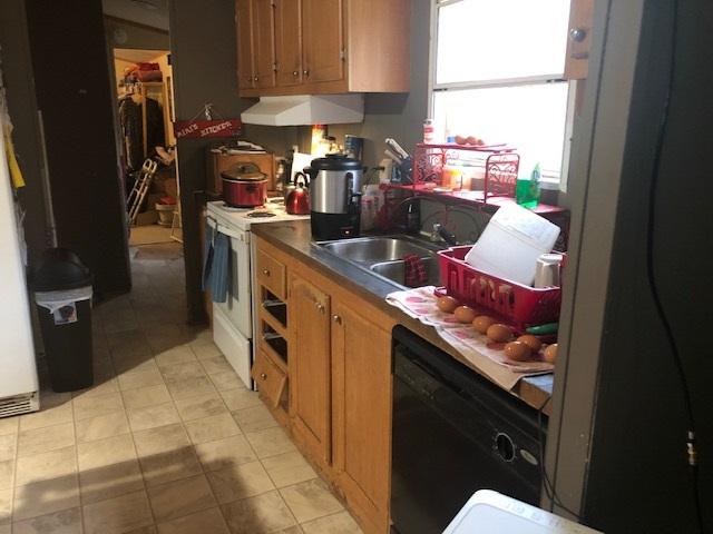 kitchen featuring dishwasher, sink, light tile floors, and electric range