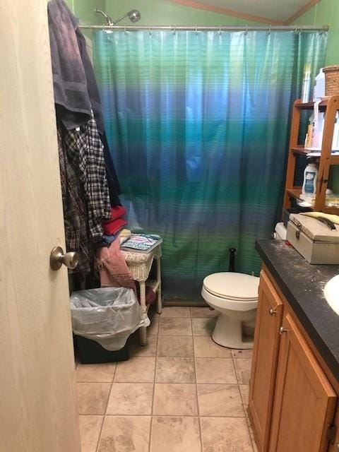 bathroom featuring toilet, tile flooring, and vanity