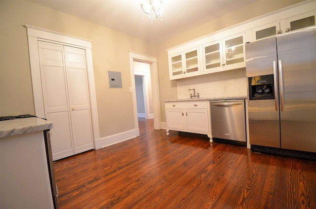 kitchen with appliances with stainless steel finishes, dark wood-type flooring, and white cabinets