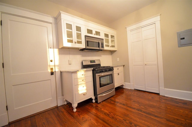 kitchen featuring backsplash, dark hardwood / wood-style floors, stainless steel appliances, and white cabinets