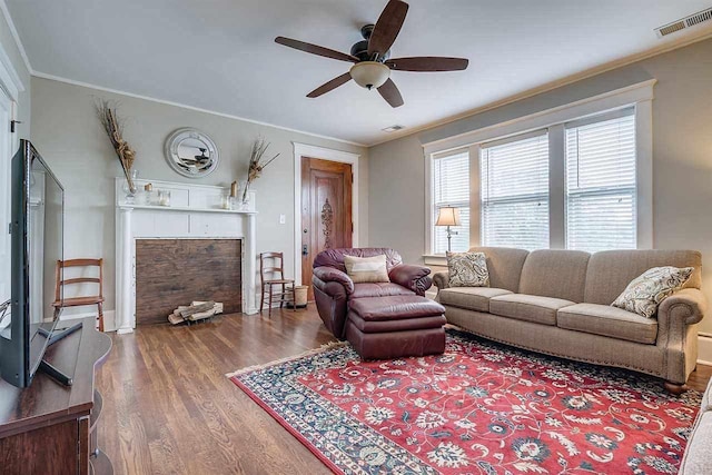 living room featuring ceiling fan, ornamental molding, and dark wood-type flooring