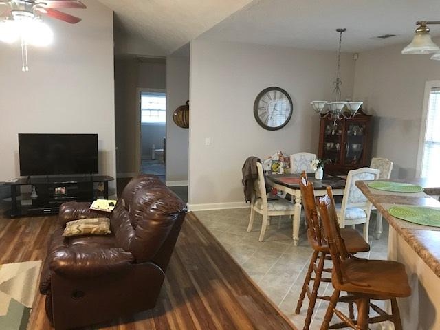 interior space with light tile floors and ceiling fan with notable chandelier