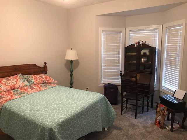 bedroom with dark colored carpet