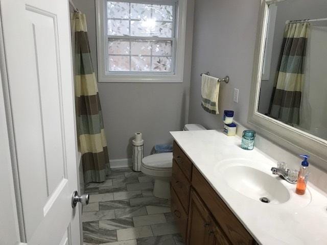 bathroom with tile flooring, toilet, and vanity