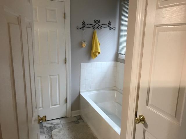 bathroom with a tub and tile floors