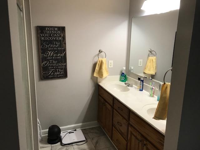 bathroom featuring dual sinks, large vanity, and tile floors