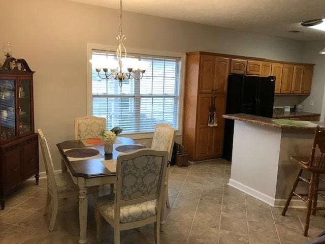 tiled dining space with a chandelier