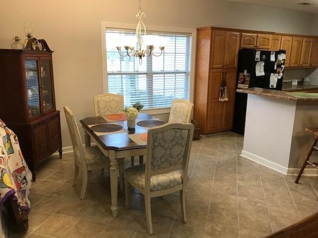 tiled dining space with a chandelier