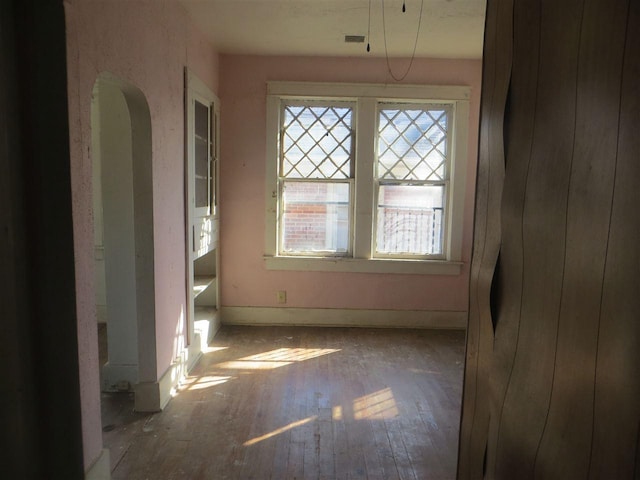 unfurnished room with plenty of natural light and hardwood / wood-style floors