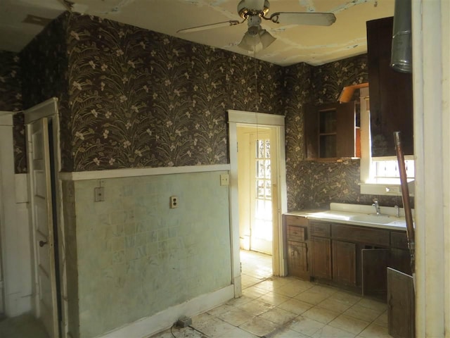 kitchen featuring ceiling fan, sink, and light tile floors