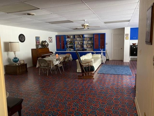 dining area featuring ceiling fan and a drop ceiling