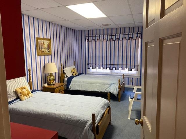 bedroom featuring a paneled ceiling and carpet flooring