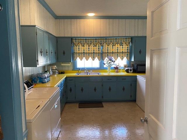 kitchen with washing machine and clothes dryer, sink, and ornamental molding