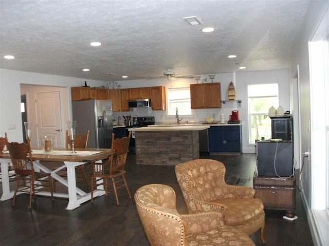 interior space featuring a textured ceiling, dark hardwood / wood-style flooring, ceiling fan, and sink