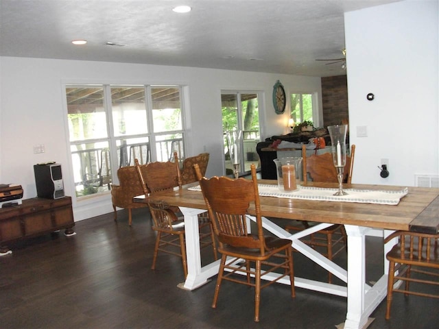 dining space with ceiling fan and dark wood-type flooring