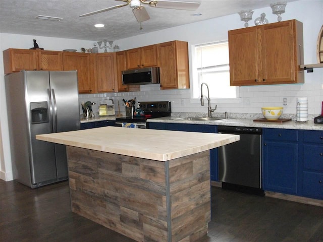 kitchen with a kitchen island, tasteful backsplash, ceiling fan, and stainless steel appliances