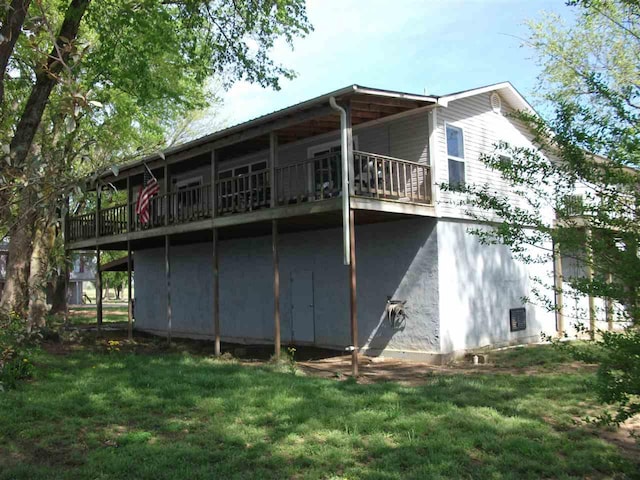 back of house with a wooden deck and a lawn