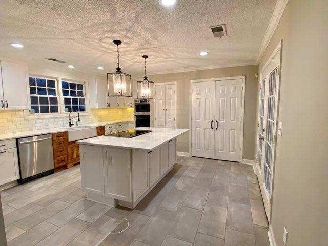 kitchen with stainless steel appliances, a center island, tasteful backsplash, white cabinetry, and sink