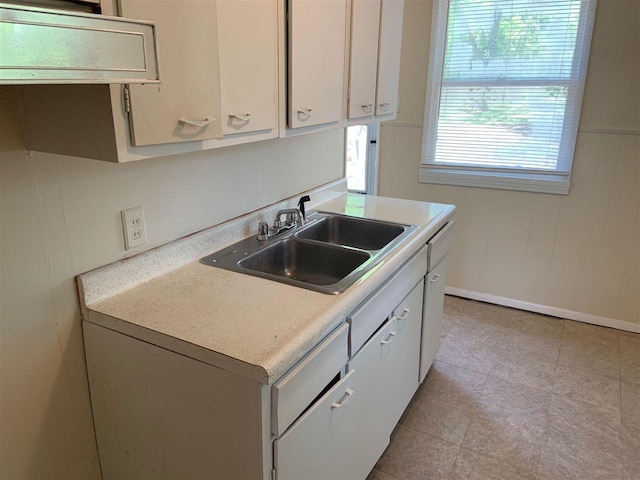 kitchen with white cabinets, sink, and light tile floors