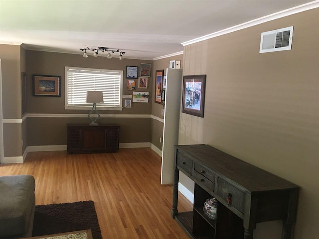 living room with crown molding and light wood-type flooring