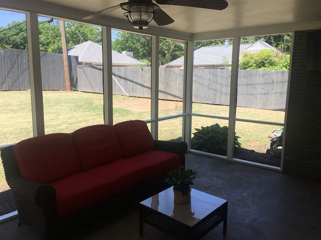 sunroom / solarium featuring a healthy amount of sunlight and ceiling fan