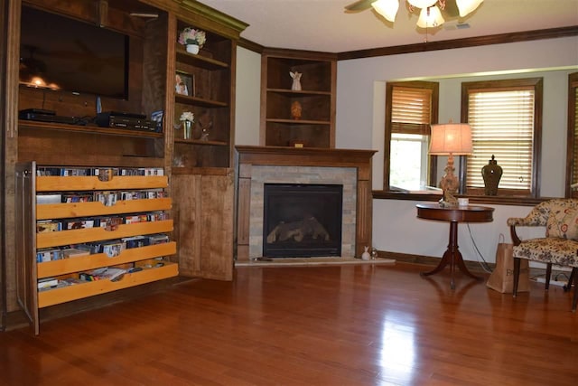 living area featuring crown molding, dark hardwood / wood-style floors, and ceiling fan