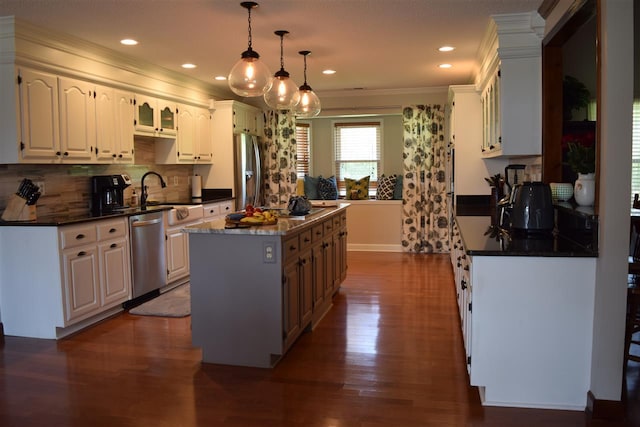 kitchen featuring dark hardwood / wood-style floors, a kitchen island, stainless steel appliances, and white cabinetry