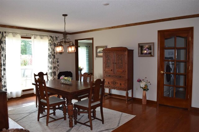 dining space featuring an inviting chandelier, ornamental molding, and dark wood-type flooring